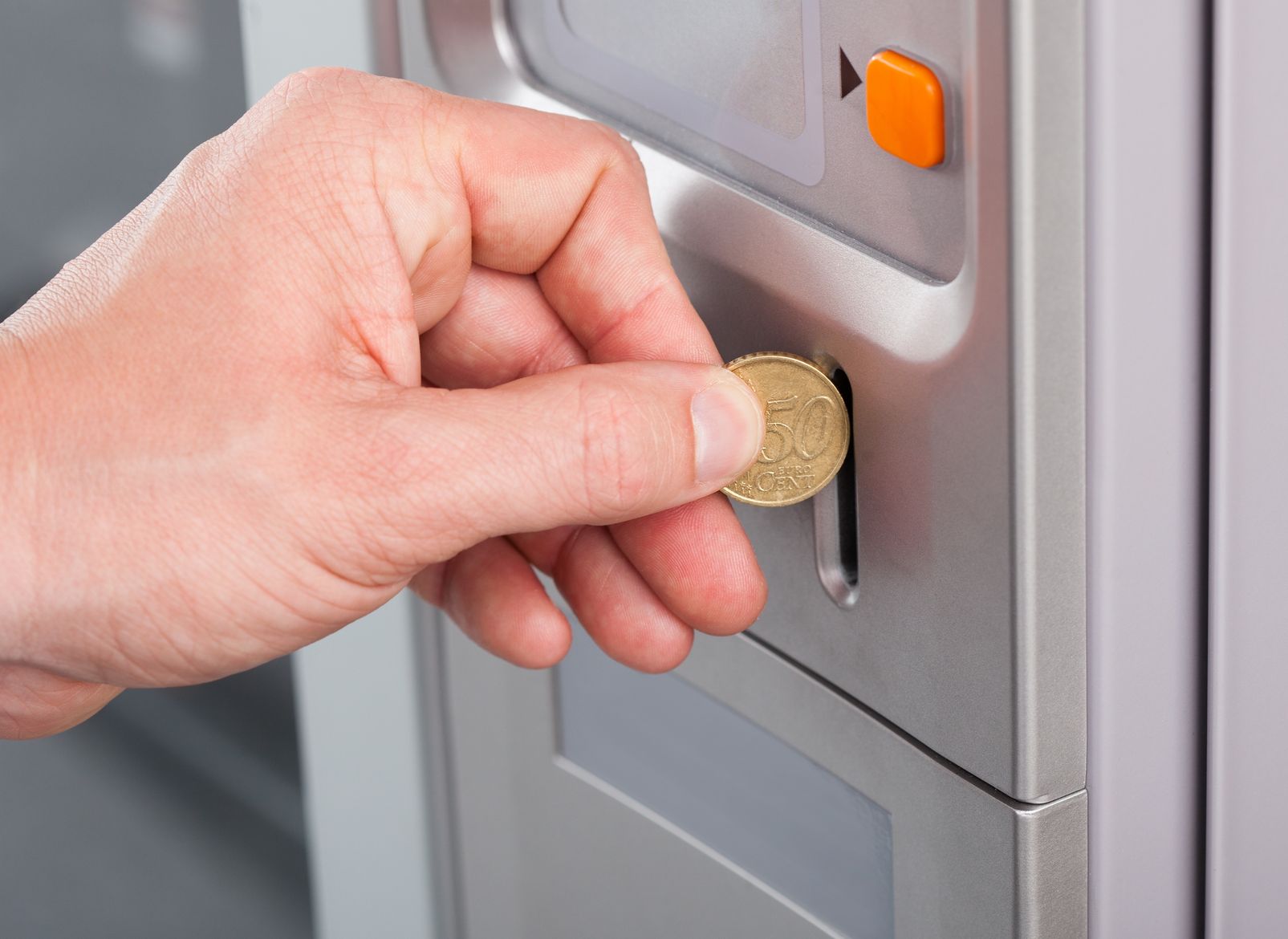 21328457 - close-up of human hand inserting coin in vending machine
